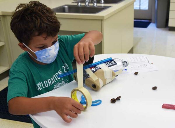 Elisabeth Morrow School 2020 Explorations student works on a science project while wearing a mask.