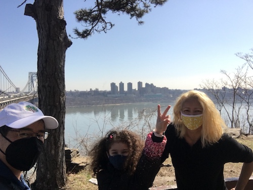 family outside by a tree and the Hudson River