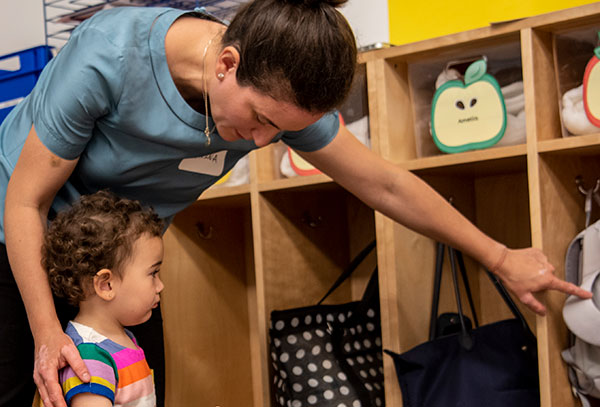 A Chilton House teacher showing a new student their cubby.