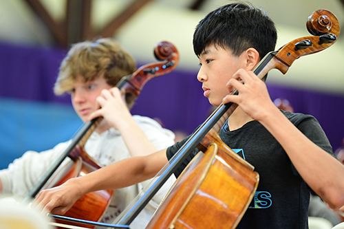 two students playing the cello
