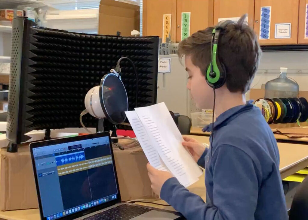 Student using MacBook for audio recording.