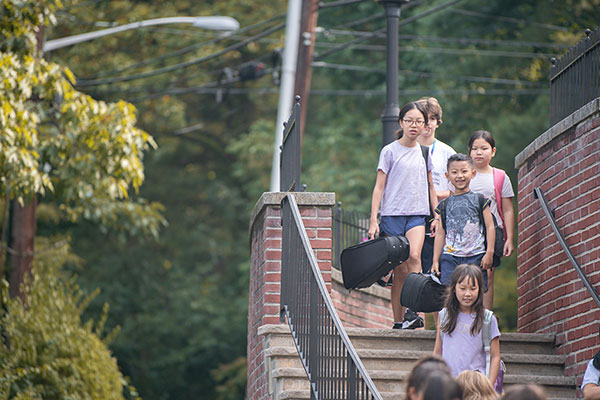 Students walking down school steps to camp/