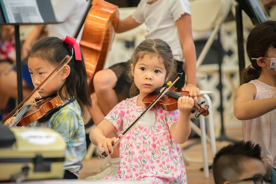 Young students performing with their violins.