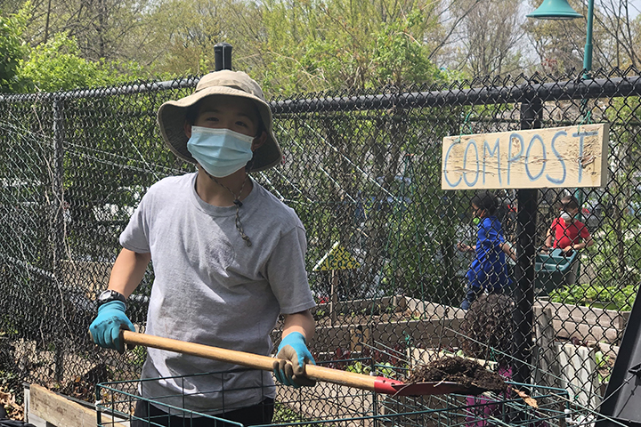 A student helping compost in the EMS garden.