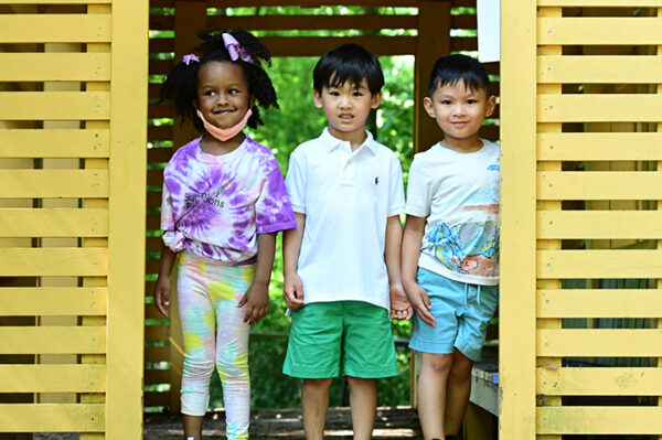 Three young campers posing on playground during Summer Explorations