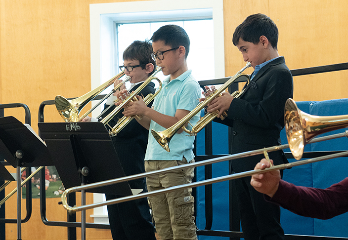 A trio of students playing trumpets.