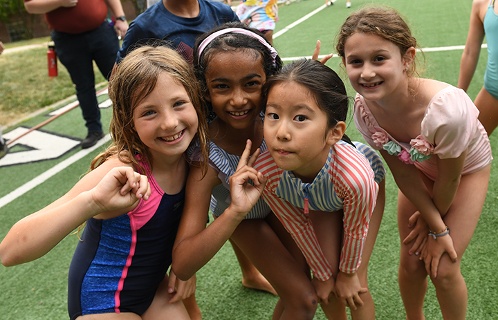 Four campers smiling during water play