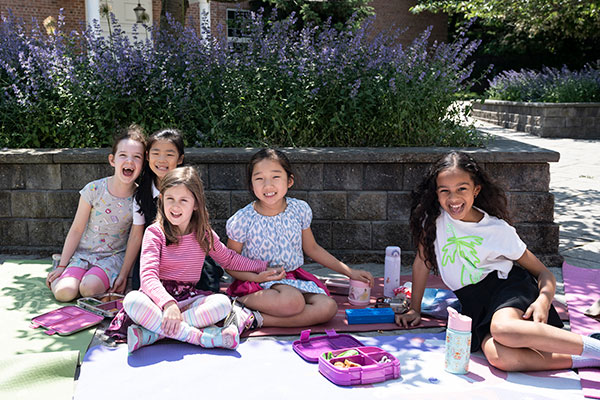 A group of students enjoying lunch together and smiling.