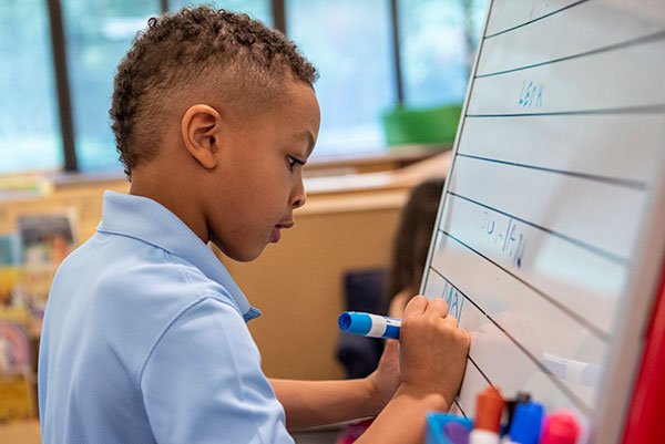 Kindergartener working on his writing in Chilton House