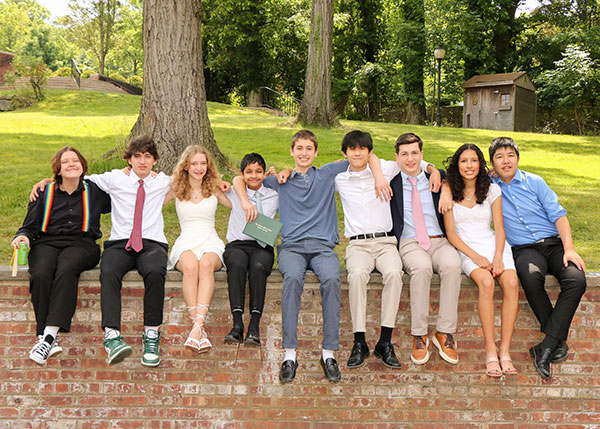 A few of our 2023 graduates sitting together in the Morrow House courtyard