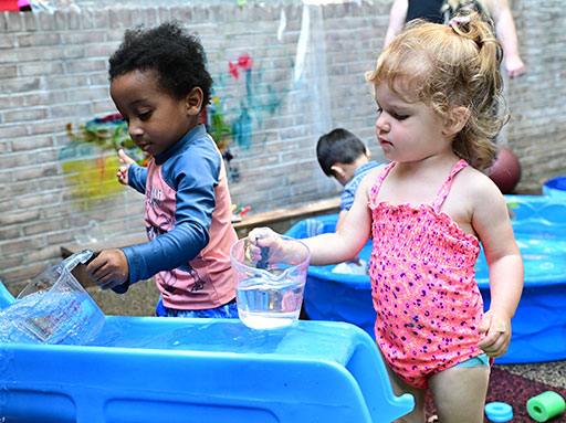Two Summer Explorations campers enjoying water play together