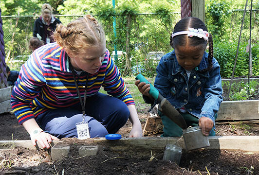 Teacher helping Chilton House student in the EMS garden