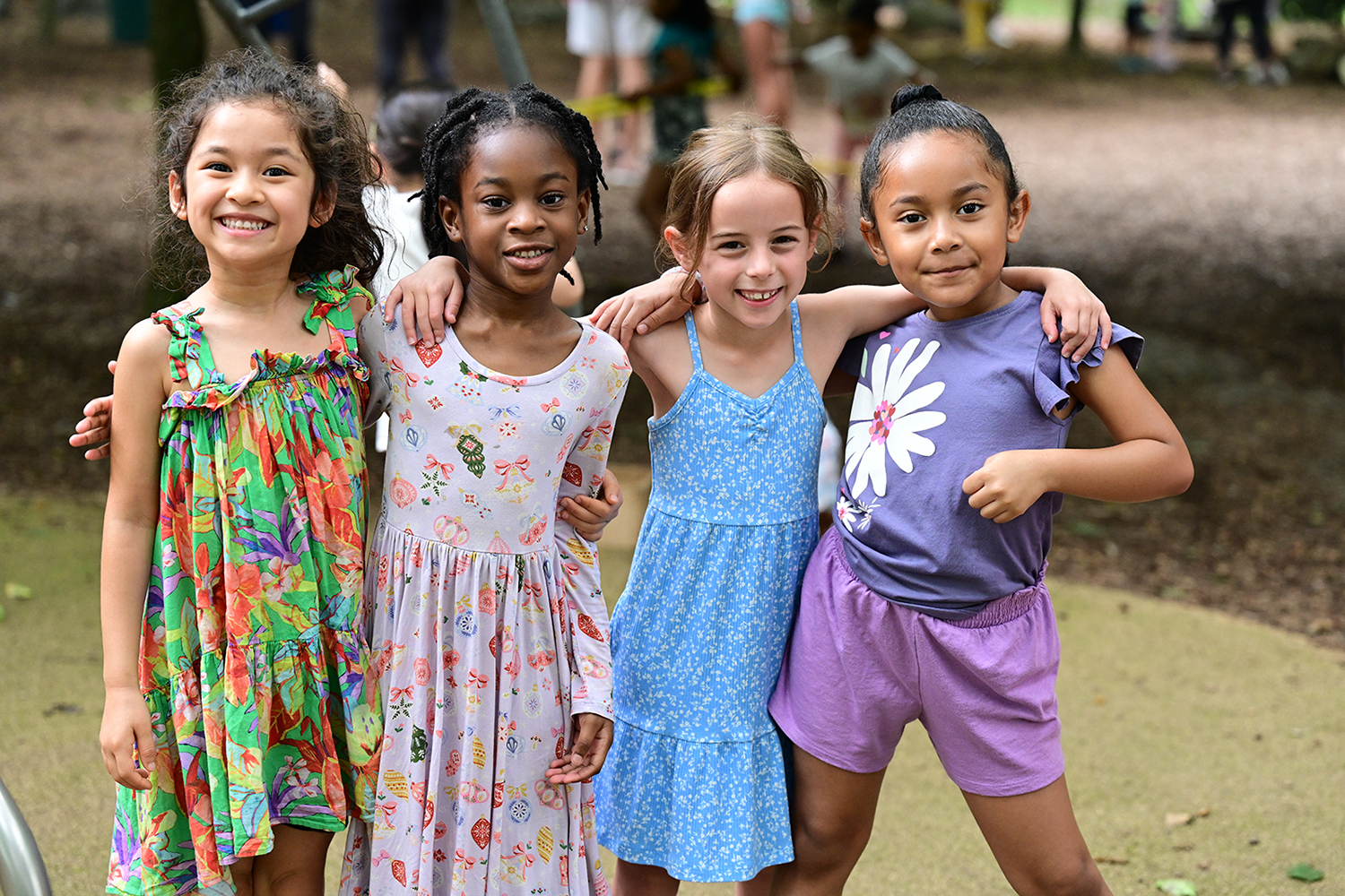 Four young girls smiling together at Summer Explorations