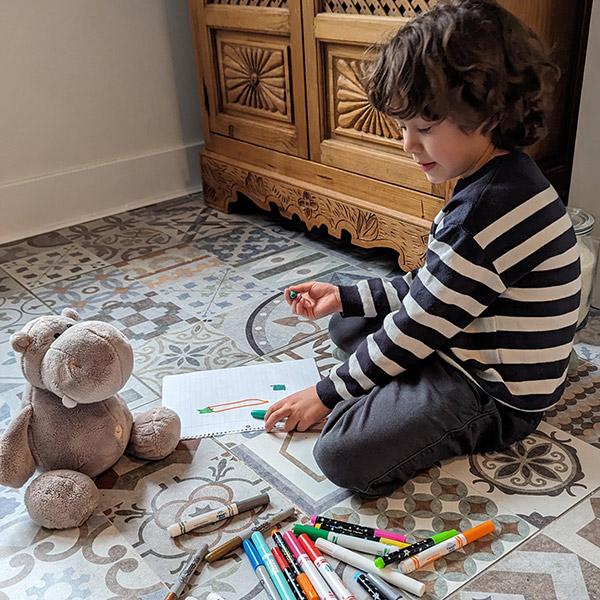 A 3s/4s student enjoying craft time at home with the class stuffed animal.