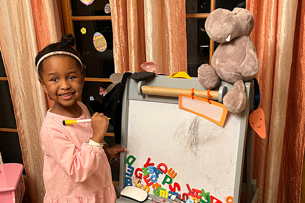 A 3s/4s student enjoying craft time at home with the class stuffed animal.