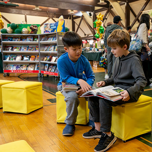 Two EMS students reading books together during our Book Fair and Storytelling Festival